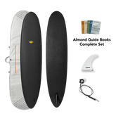 Black surfboard with accessories including a cover, fins, and guide books on a white background